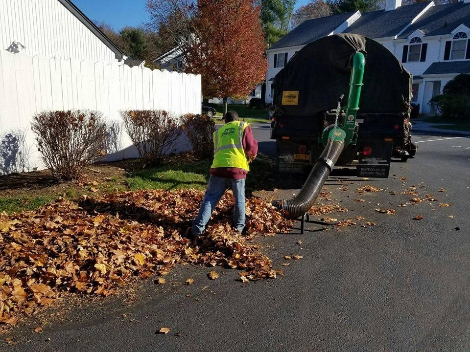 Villegas crew member clearing fall leaves with a vacuum truck